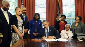 The Congressional Gold Medal has been posthumously awarded to four girls killed in the 1963 bombing of Birmingham's 16th Street Baptist Church. President Obama signed the legislation Friday, as (from left) Birmingham Mayor William Bell, Dr. Sharon Malone Holder, Attorney General Eric Holder, Rep. Terri Sewell, and relatives of Denise McNair and Carole Robertson look on.