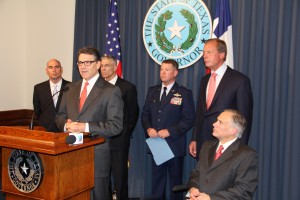 Abbott listens as Perry announces deployment of National Guard on the Texas border.