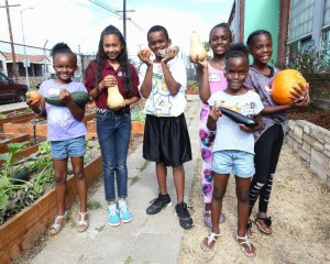 Children show off veggies raised for their first harvest.