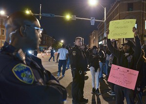 Protesters call for justice for Freddie Gray as Baltimore police officers watch. Photo source:NNPA News Wire Service) 