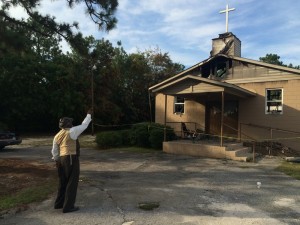 Pastor Bobby Jones points to the cross on top of Glover Grove Baptist Church, where he has preached for more than 30 years. The steeple was one of the only parts of the church left standing. Will Huntsberry/NPR