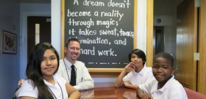 Ben Dickerson, the new principal of Edward H. Cary Middle School, smiles with his students. Photo courtesy of Dallas ISD.