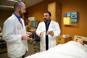 Elias Villarreal, UTRGV associate professor in the Department of Physician Assistant (center) and Marc Geller, third-year student in the program, display the PA program’s use of iPads, simulation dummies and other technologies in patient treatment. (UTRGV Photo by Paul Chouy)