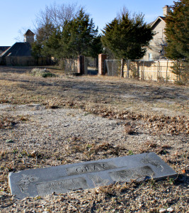 The tops of modern developments are visible above the wooden fence as the historic White Rock Garden of Memories Cemetery is now completely surrounded by apartment communities. (NDG Photo by David Wilfong)