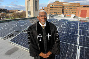 Washington, DC, USA--Rev. Dr. Earl D. Trent Jr., Senior Pastor at Florida Avenue Baptist Church stands among the solor panels that are on top of the church roof. Jocelyn Augustino/Urban News Service