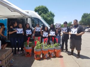 Students in the biology club at Barbara Cardwell Career Preparatory Center presented ten families with self-sustaining garden planters as part of a community outreach project. (Image: Irving ISD)